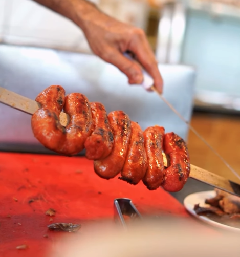 Linguiça assada sendo preparada na hora